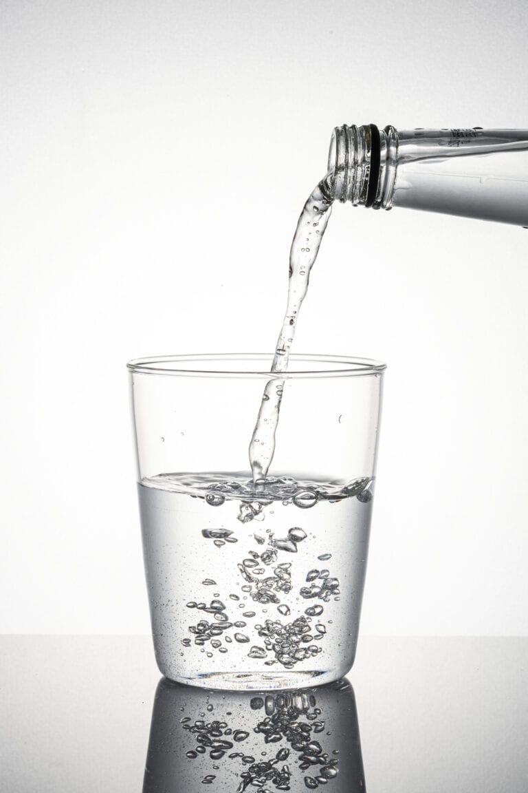 Vannflaske som heller vann i et glass