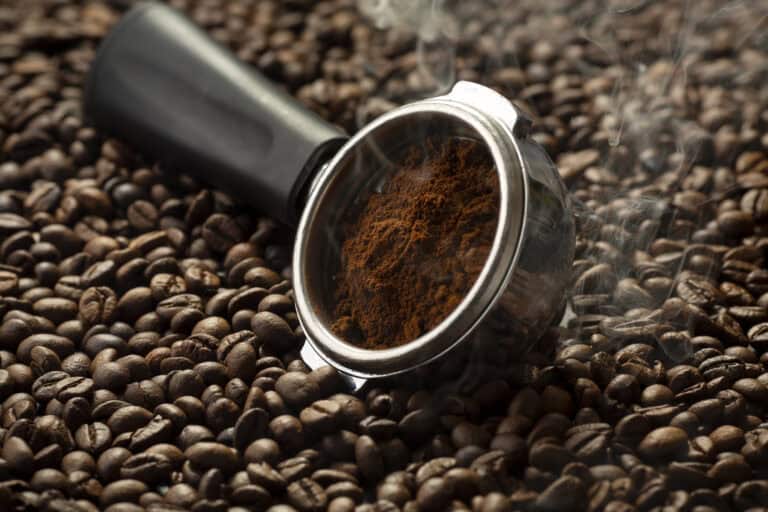Kvernet kaffe på toppen av kaffebønner